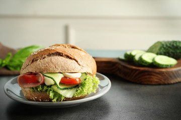 Tasty sandwich with fresh cucumber on table