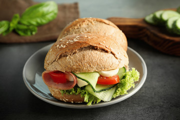 Tasty sandwich with fresh cucumber on table