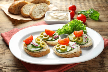 Plate of tasty sandwiches with fresh cucumber on table