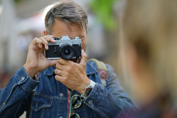 Mature trendy guy taking picture on journey