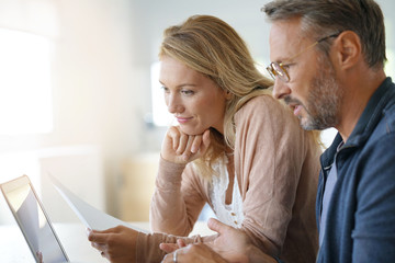 Mature couple at home working on laptop computer