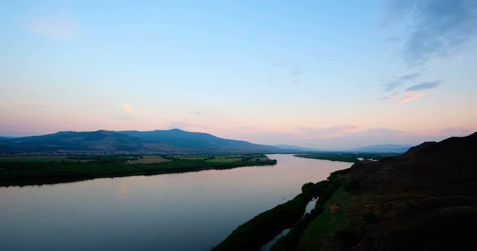 Timelapse, beautiful sunset, in the background a river t mountains