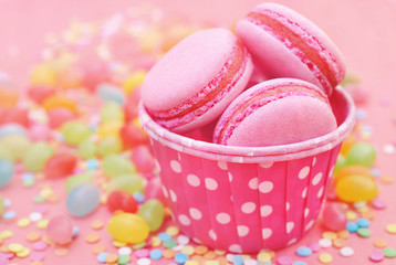 Colorful macarons on bright festive decor background, selective focus