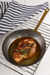 grilled pork chop with oil in a pan