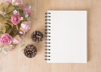 blank note book with rose flower on wood table.