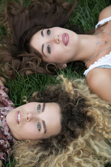 Two women lay and rest on a grass