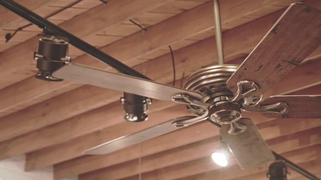 Ceiling fan on wooden roof. Electric ceiling fan rotating slowly and air circulation. Air circulation. Cooling fan. Ventilation fan on ceiling. Wooden roof background