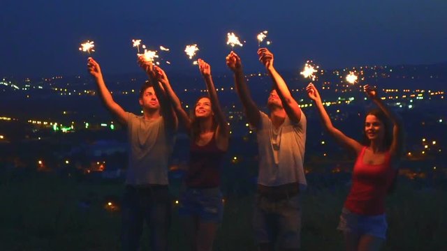 The happy people hold bengal lights. slow motion, evening night time