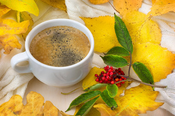 Coffee and yellow autumn leaves with red berries