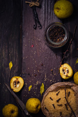 Ingredients tinctures Fruits twigs quince sugar cloves vanilla wooden table