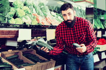 Shop assistant demonstrating zucchinis