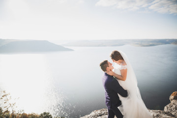 Happy and romantic scene of just married young wedding couple posing on beautiful beach