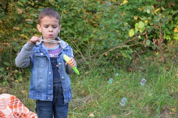 Little boy with bubbles in the field