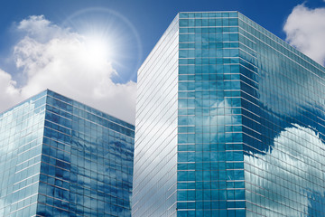 Fototapeta na wymiar Blue sky and clouds reflecting in windows of modern office building