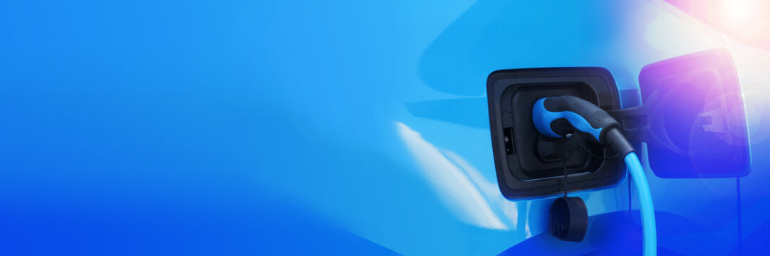 Elektroauto mit Ladestecker - Aufladevorgang an Ladestation - Elektromobilit&auml;t - Freien Platz f&uuml;r Ihren Text oder Logo