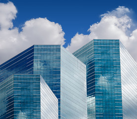 Fototapeta na wymiar Blue sky and clouds reflecting in windows of modern office building