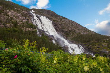 Summer mountain Langfossen waterfall on slope (Etne, Norway).