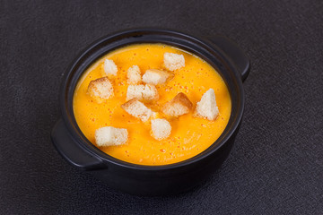 Pumpkin and carrot soup with cream and parsley
