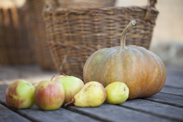 Halloween pumpkin on a wooden background with autumn apples and pears