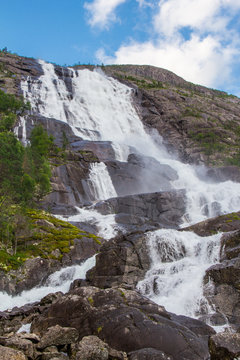 Summer mountain Langfossen waterfall on slope (Etne, Norway).
