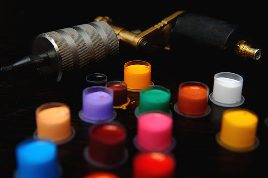 colored tattoo ink in the caps for tattoo ink on a gold background tattoo machine