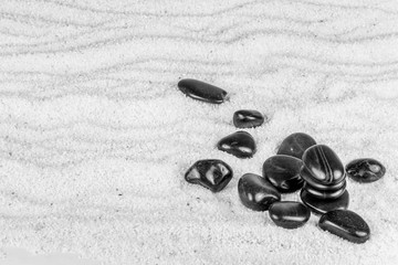 Fototapeta na wymiar galets sur sable en noir et blanc 