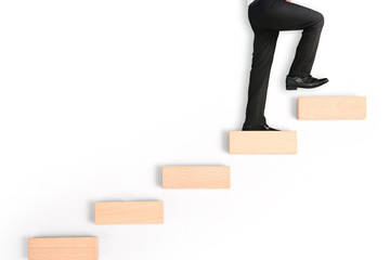 business person stepping up  toy staircase