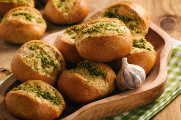 Homemade garlic bread rolls on wooden background.