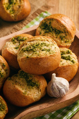 Homemade garlic bread rolls on wooden background.