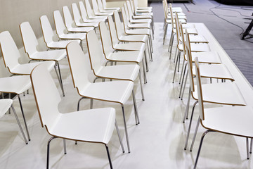 Rows of white chairs in presentation room