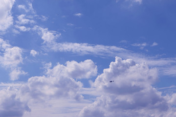 The helicopter Fly in bright blue sky with a big white clouds on a beautiful day