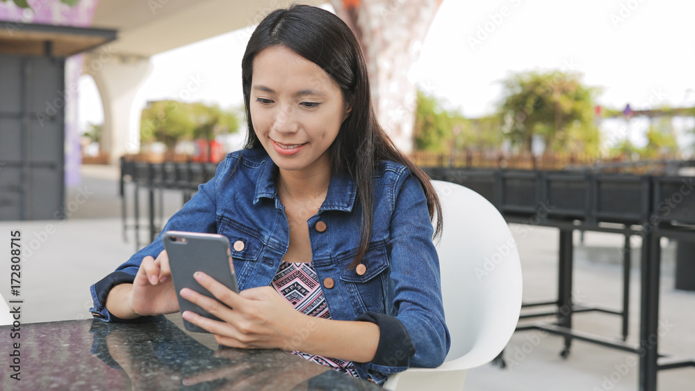 Poster Woman using cellphone in outdoor cafe