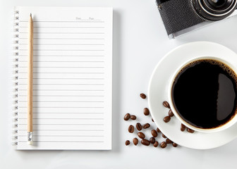 Top view of black coffee and blank notebook