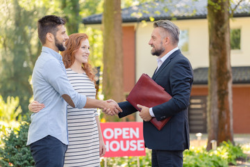 Real estate agent welcoming couple