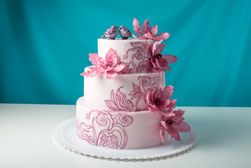 A beautiful home wedding three-tiered cake decorated with pink flowers