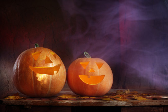 Halloween pumpkins on wooden table on dark background
