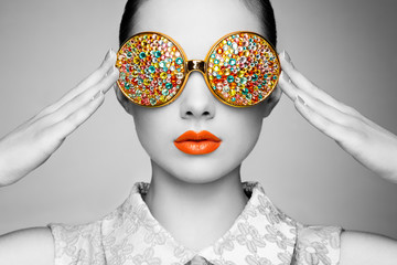Portrait of beautiful young woman with colored glasses. Beauty fashion. Perfect make-up. Colorful...