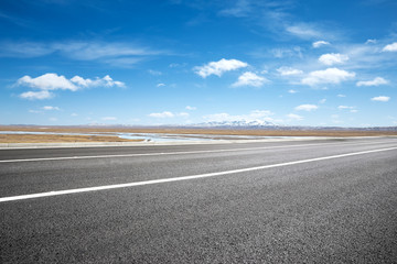 Fototapeta premium empty asphalt road with snow mountains