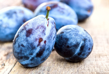 Fresh ripe plums on a wooden background