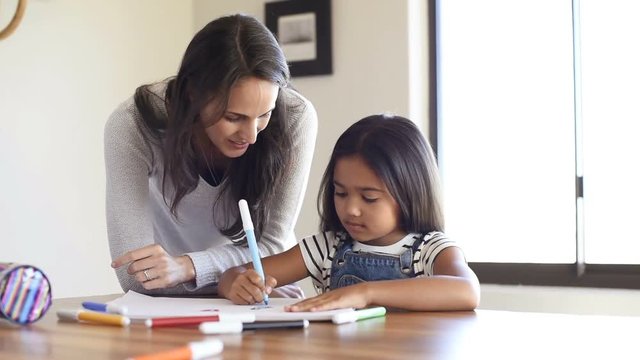 Mother helping daughter draw