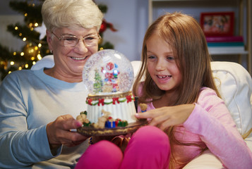 Senior woman with granddaughter holding a christmas decoration