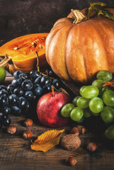 Autumn and thanksgiving harvest concept. Seasonal fall fruits and pumpkin on wooden table, copy...