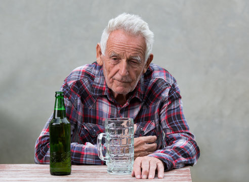 Senior man with beer bottle and mug