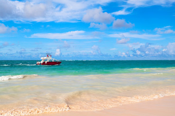 Coastal Caribbean landscape with red motorboat
