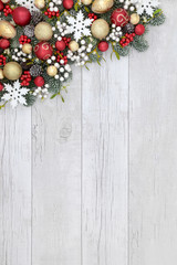 Christmas festive background border with bauble decorations, holly, mistletoe, ivy, fir and pine...