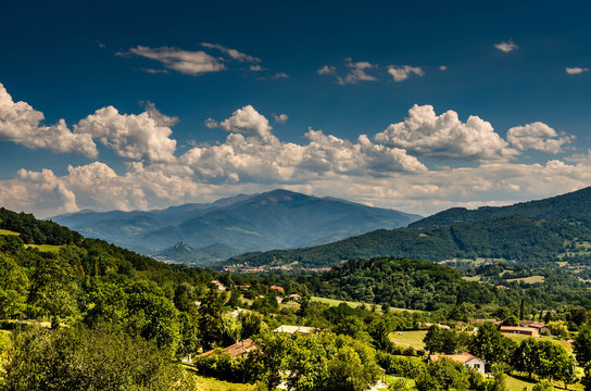 A valley near Foix in France with trees and mountains in background