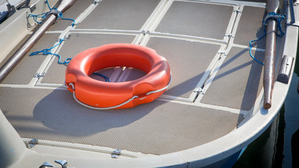 orange lifebuoy on deck of a white boat