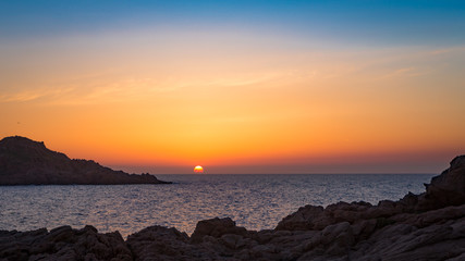 mediterranean beach at sunset with orange sky