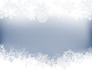 Winter background. White  border made of fluffy snowflakes with space for text on soft blue background .