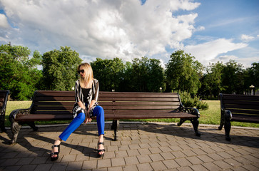 Красивая, стильная девушка со светлыми волосами сидит...